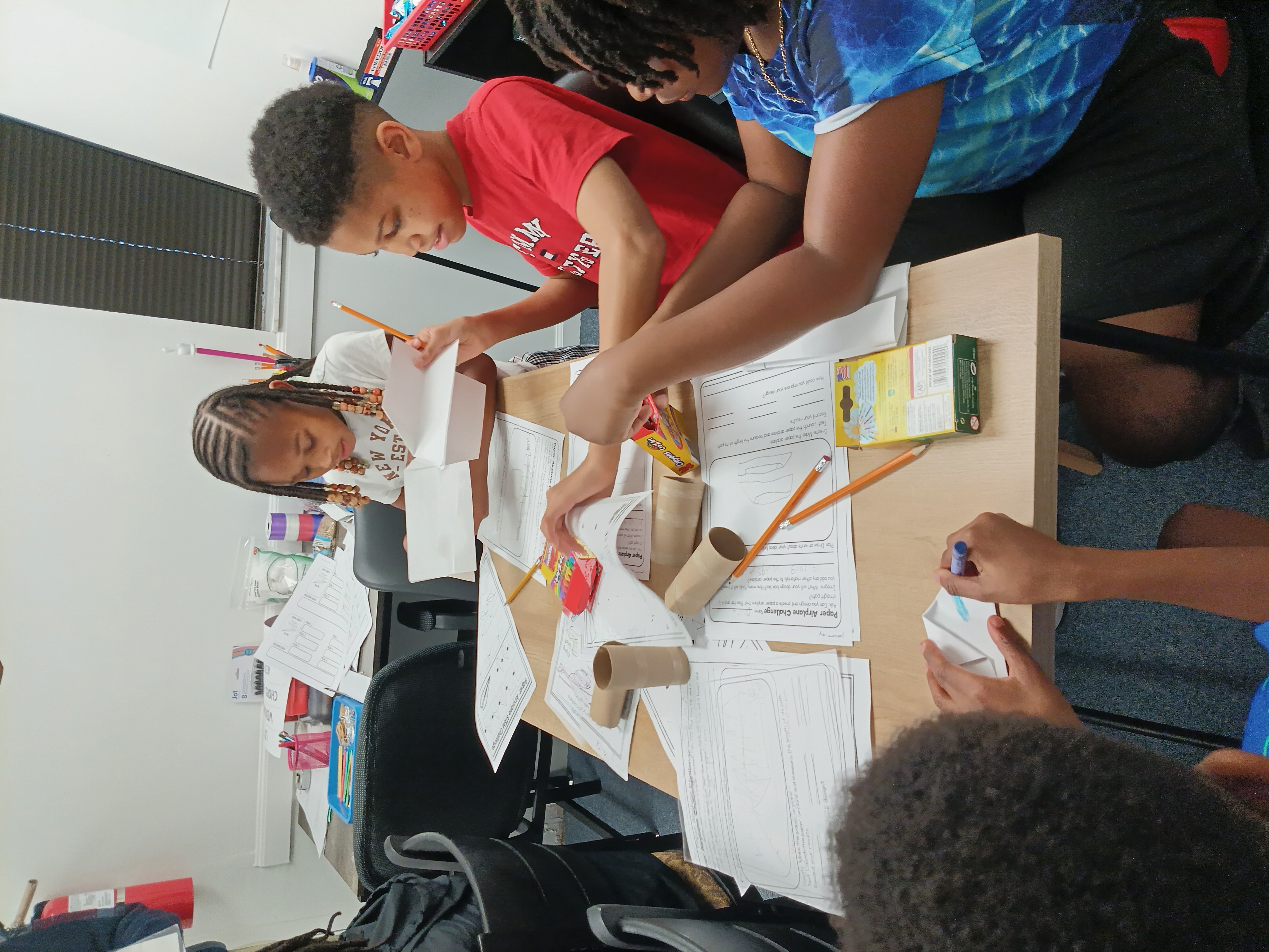 Participants creating paper aircraft for STEAM challenge